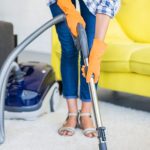 close up woman s hand cleaning carpet with vacuum cleaner